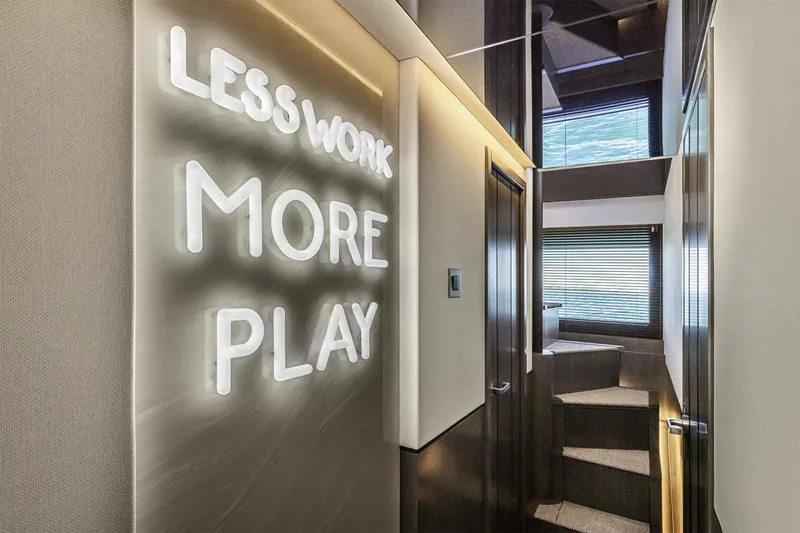 Slide: The Image of Interior of 2023 Pearl 72 Motor Yacht with "Less Work More Play" neon sign. - 10