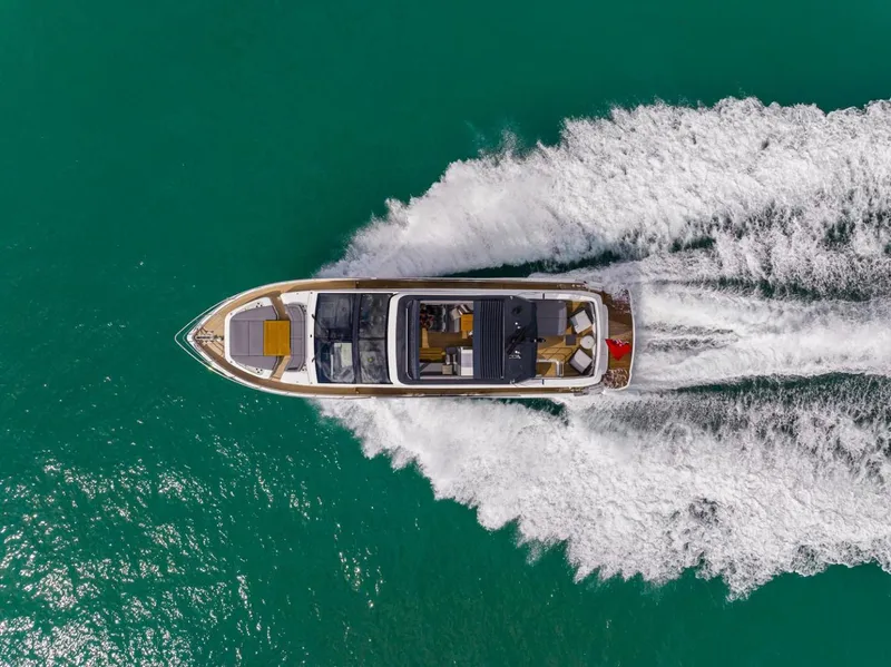Slide: The Image of 2023 Pearl 72 Motor Yacht cruising on turquoise water, aerial view. - 2