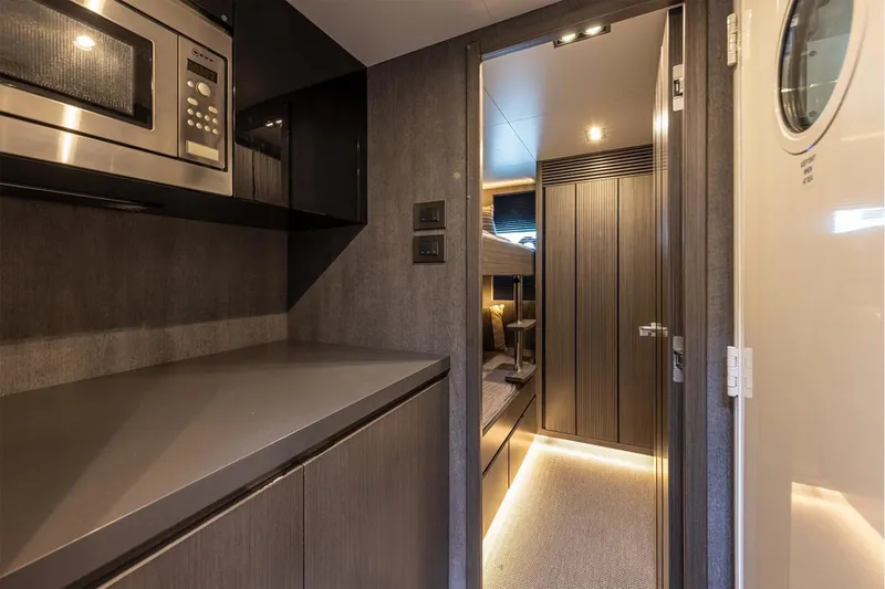 Slide: The Image of Interior of 2023 Pearl 72 Motor Yacht, featuring modern kitchen and cozy cabin entrance. - 23