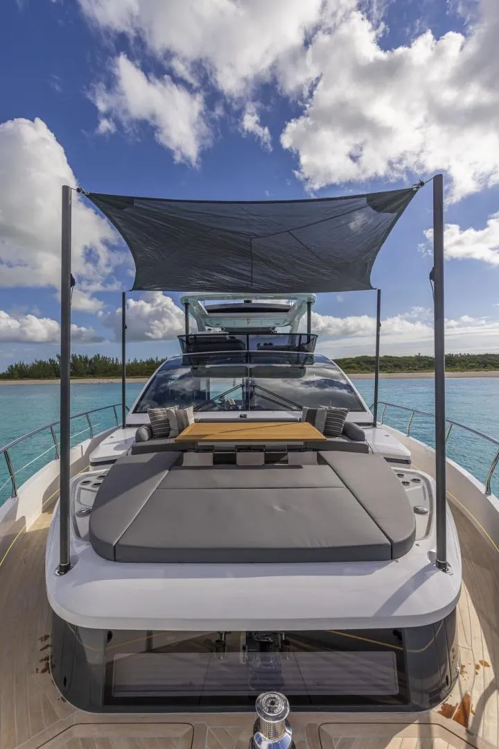 Slide: The Image of 2023 Pearl 72 Motor Yacht with sunshade, cruising on clear blue waters under a partly cloudy sky. - 35