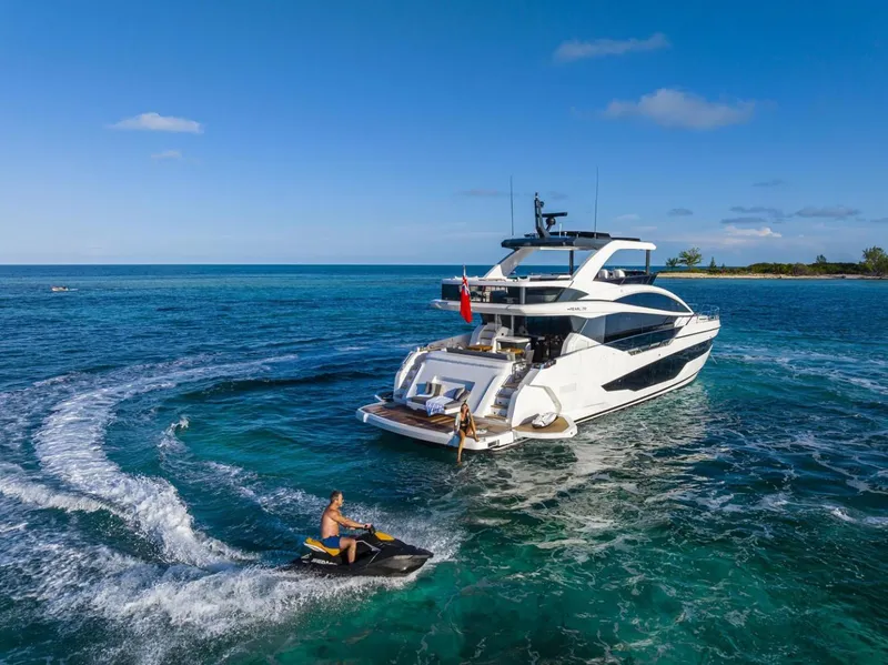 Slide: The Image of 2023 Pearl 72 Motor Yacht cruising with jet ski in clear blue ocean. - 37