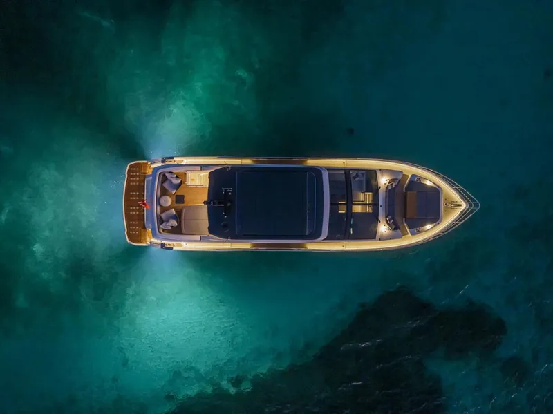 Slide: The Image of Aerial view of 2023 Pearl 72 Motor Yacht illuminated on dark water. - 38