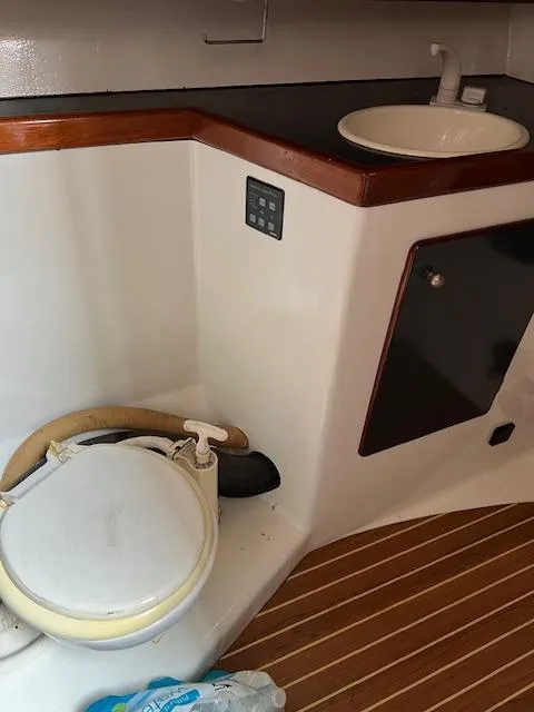 Slide: The Image of Boat bathroom with toilet, sink, and wooden flooring, Custom 38 C/R, 2003 model. - 14