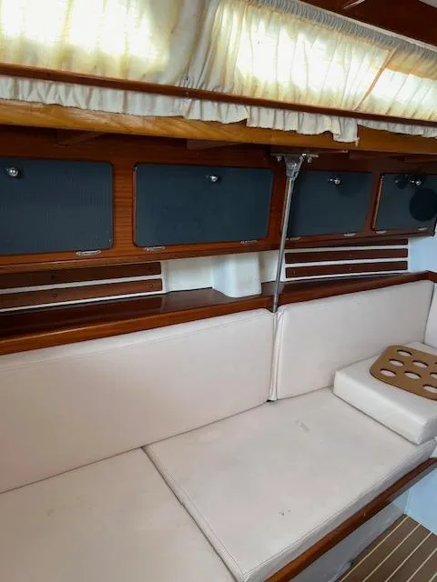 Slide: The Image of Interior of a 2003 Custom 38 C/R boat with cushioned seating and wooden accents. - 16