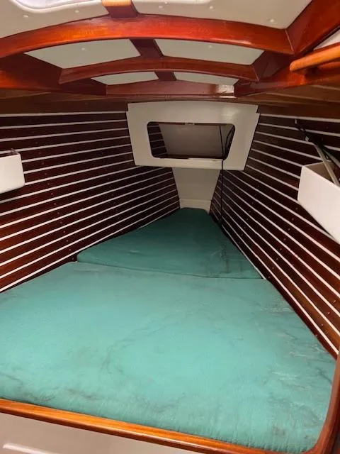 Slide: The Image of Interior of a 2003 Custom 38 C/R boat with wooden paneling and teal bedding. - 18
