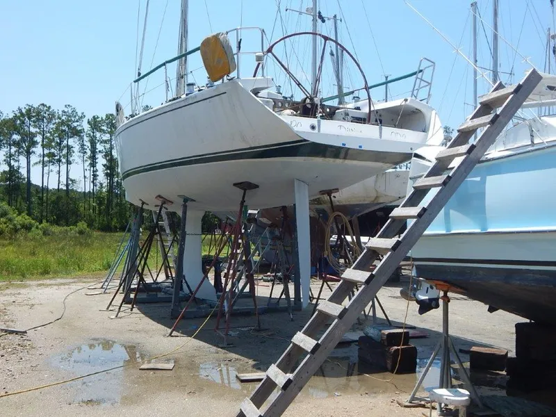 Slide: The Image of Custom 38 C/R sailboat from 2003 on stands, ladder nearby, outdoor setting. - 2