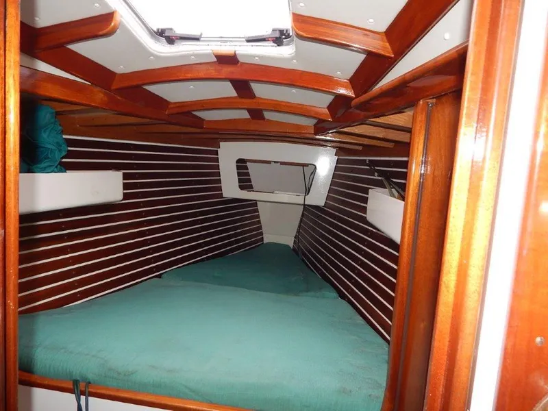 Slide: The Image of Cozy cabin interior of 2003 Custom 38 C/R boat with wooden accents and teal bedding. - 20
