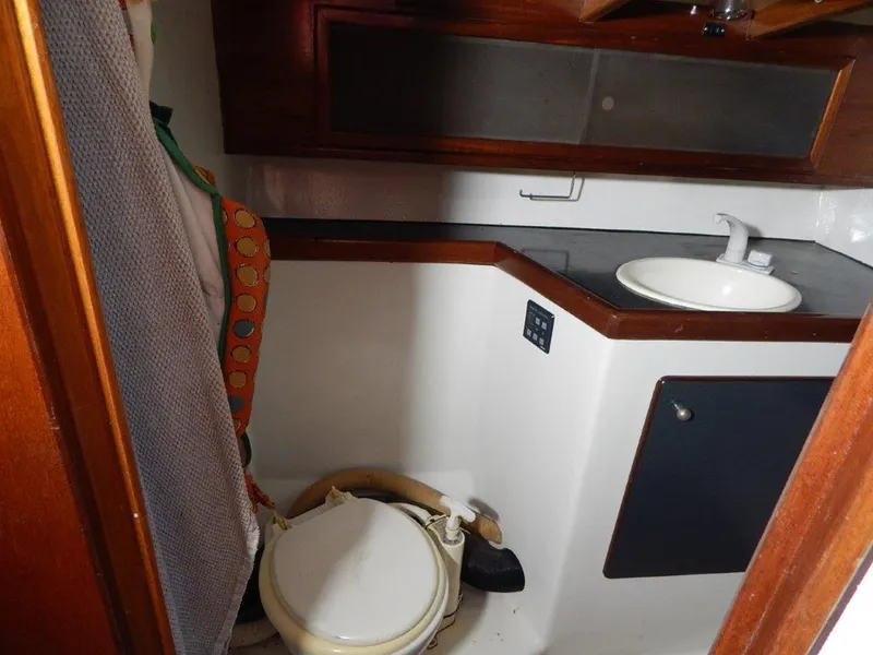 Slide: The Image of Small boat bathroom with toilet, sink, and wooden cabinets, Custom 38 C/R, 2003 model. - 24