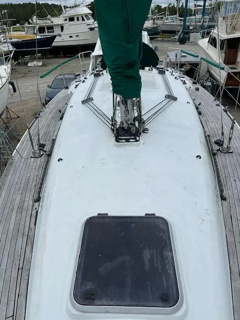 Slide: The Image of Sailboat deck of 2003 Custom 38 C/R, docked with visible rigging and hatch. - 4