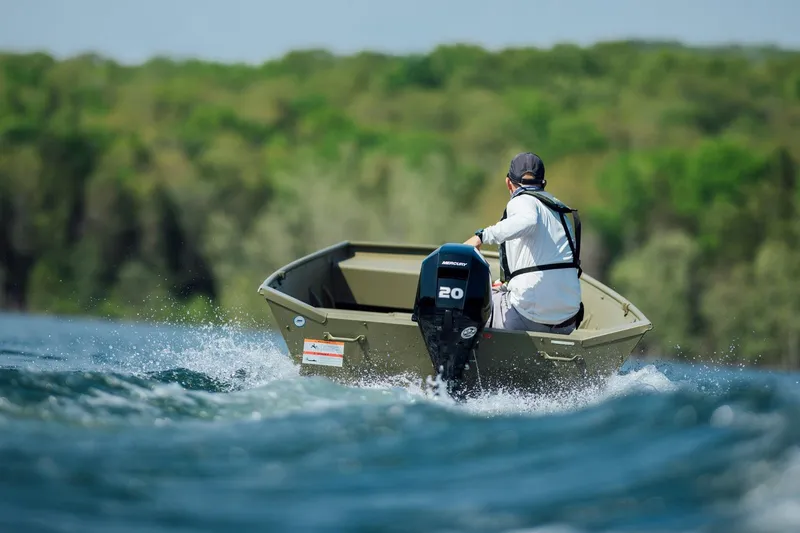 Slide: The Image of Man driving 2025 Lowe L1448M Jon boat on a lake. - 3
