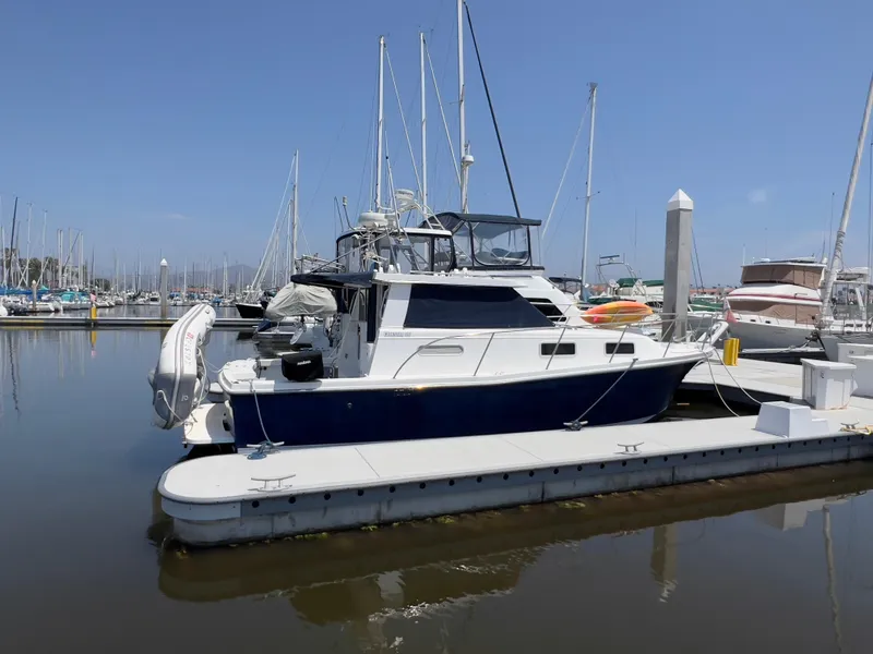 Slide: The Image of 2001 Norstar 301 boat docked at marina, surrounded by sailboats under clear blue sky. - 0