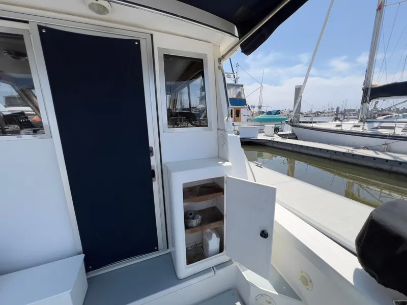 Slide: The Image of Norstar 301 boat deck with open storage, docked at marina, clear sky background. - 23
