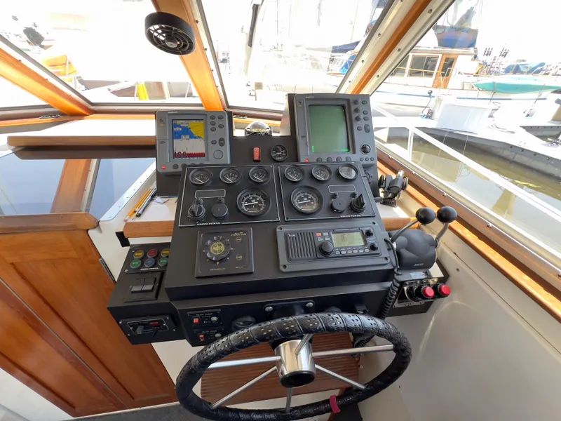 Slide: The Image of Control panel of a 2001 Norstar 301 boat with navigation instruments and steering wheel. - 29