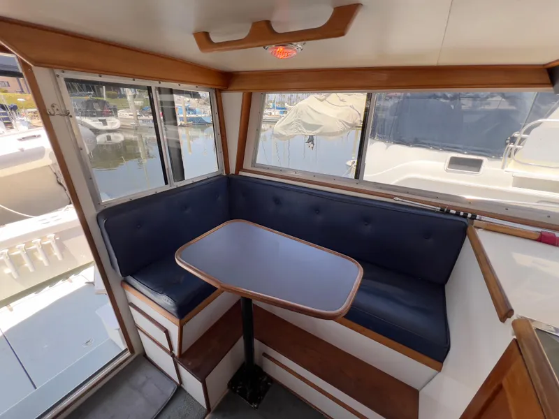 Slide: The Image of Cozy dining area in 2001 Norstar 301 boat with blue seating and waterfront view. - 30