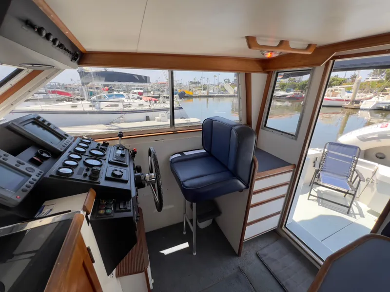 Slide: The Image of Interior of 2001 Norstar 301 boat with helm, blue seat, and marina view. - 31