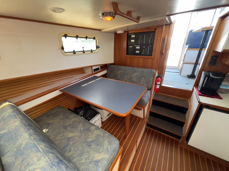 Slide: The Image of 2001 Norstar 301 boat interior with dining area, wooden flooring, and control panel. - 37