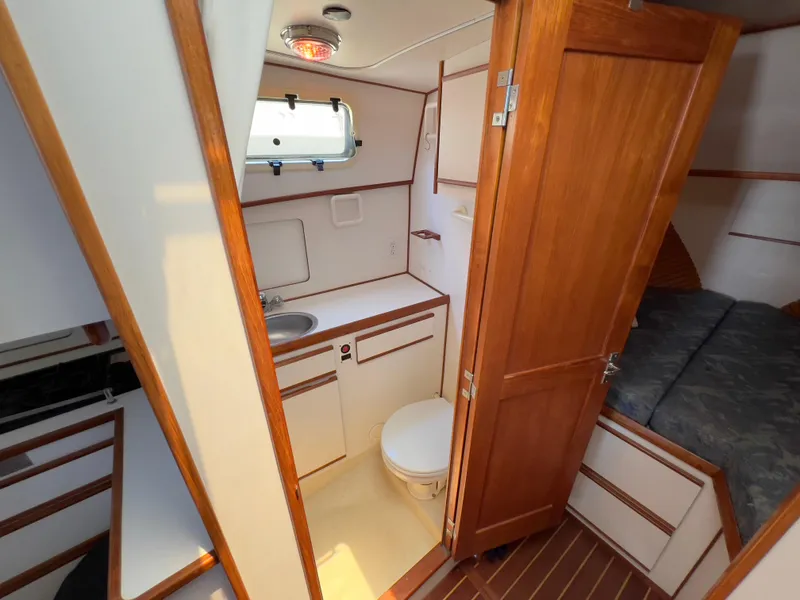 Slide: The Image of 2001 Norstar 301 boat interior with wooden cabinetry, compact bathroom, and cozy sleeping area. - 39