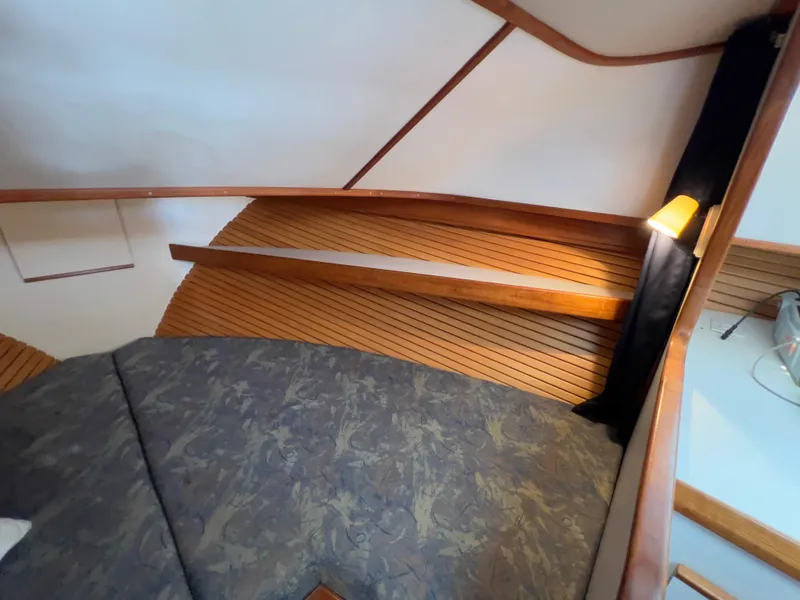 Slide: The Image of Cozy cabin interior of 2001 Norstar 301 boat with wooden accents and cushioned seating. - 42