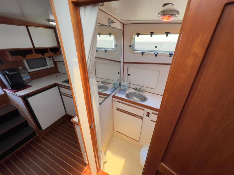 Slide: The Image of Interior of 2001 Norstar 301 boat featuring compact kitchen and bathroom area. - 43