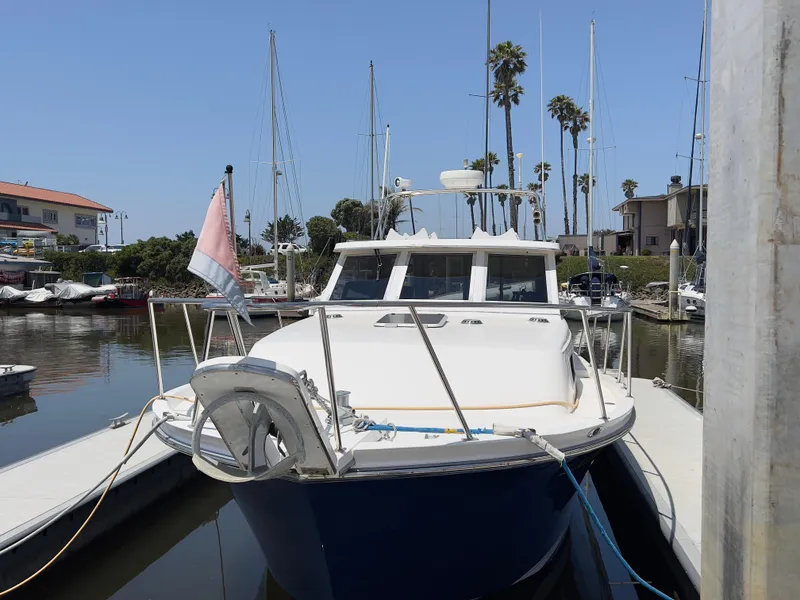 Slide: The Image of Norstar 301 boat docked in marina, 2001 model, clear sky, palm trees in background. - 7