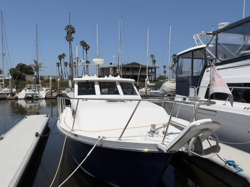 Slide: The Image of 2001 Norstar 301 boat docked in a marina with palm trees and sailboats. - 8