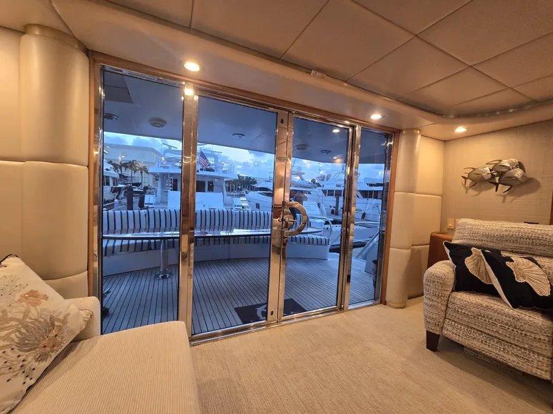 Slide: The Image of Luxurious interior of 1994 Hatteras 82 Convertible yacht with plush seating and marina view. - 10