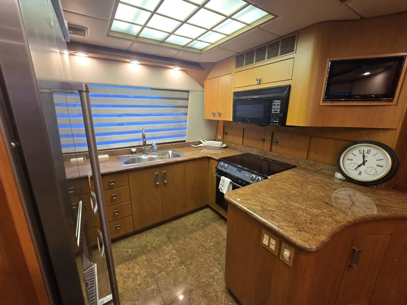Slide: The Image of Kitchen interior of 1994 Hatteras 82 Convertible yacht with modern appliances and wood cabinetry. - 12