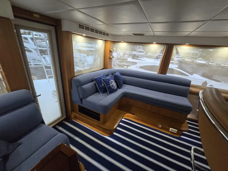 Slide: The Image of Luxurious interior of 1994 Hatteras 82 Convertible yacht with blue seating and striped carpet. - 17