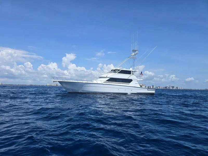 Slide: The Image of 1994 Hatteras 82 Convertible yacht on open sea under clear blue sky. - 35