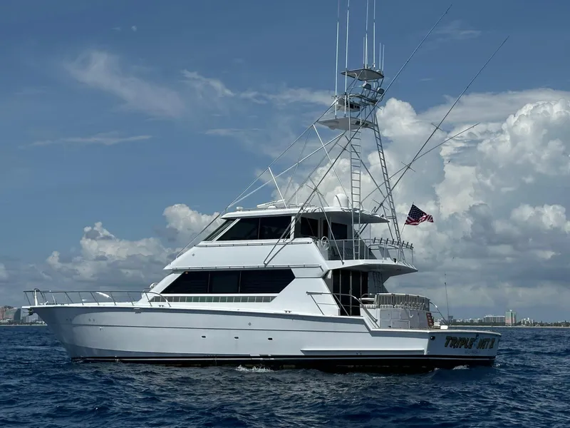 Slide: The Image of 1994 Hatteras 82 Convertible yacht cruising on open water under a clear sky. - 36