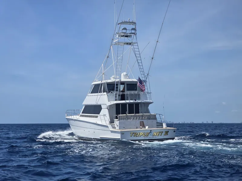 Slide: The Image of 1994 Hatteras 82 Convertible yacht cruising on open sea under clear sky. - 38