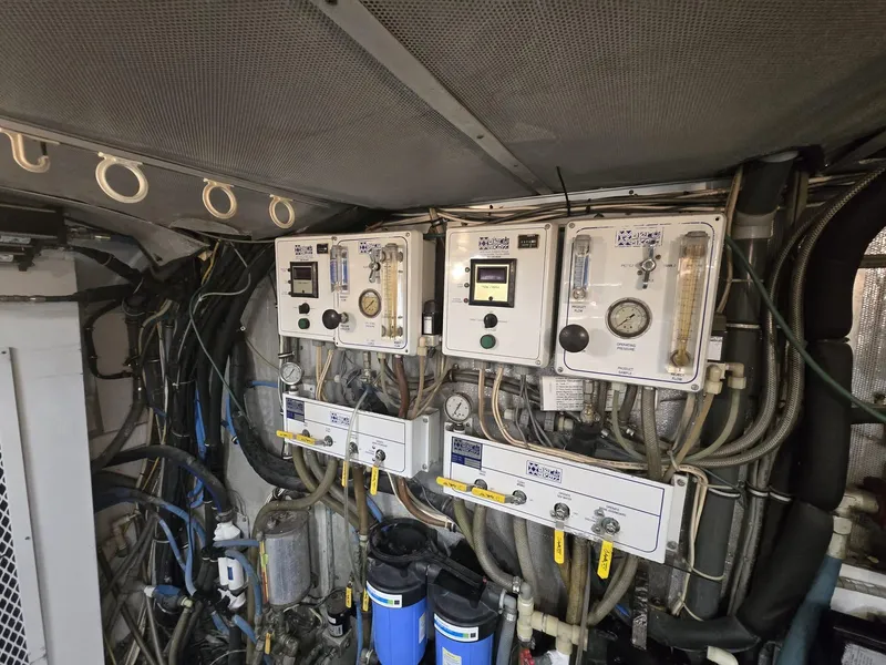 Slide: The Image of Engine room of 1994 Hatteras 82 Convertible yacht with control panels and wiring. - 50