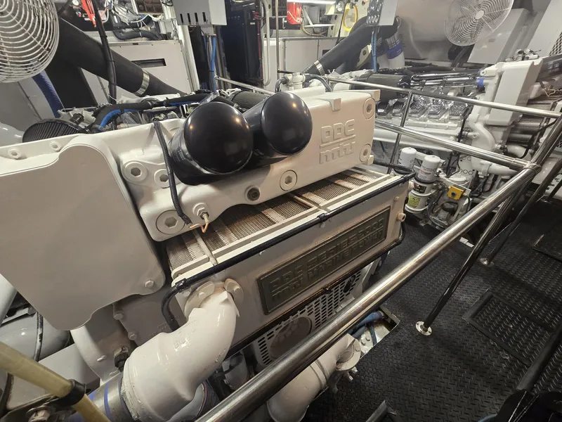 Slide: The Image of Engine room of a 1994 Hatteras 82 Convertible yacht, showcasing machinery and components. - 52