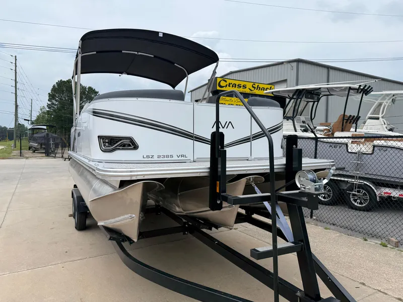 Slide: The Image of 2025 Avalon LSZ Versatile Rear Lounger pontoon boat on trailer, outdoor display. - 4