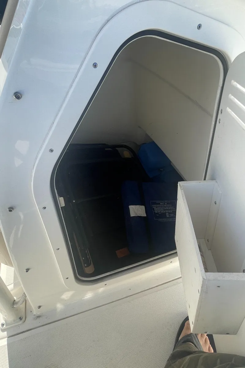 Slide: The Image of Storage compartment on a 2021 Boston Whaler 210 Montauk boat, containing life jackets. - 10