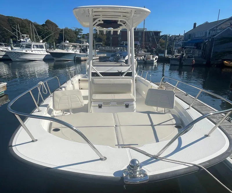 Slide: The Image of 2021 Boston Whaler 210 Montauk boat docked in a marina, showcasing spacious deck and seating. - 12