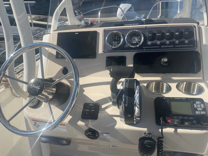 Slide: The Image of Control panel of a 2021 Boston Whaler 210 Montauk boat with steering wheel and gauges. - 3