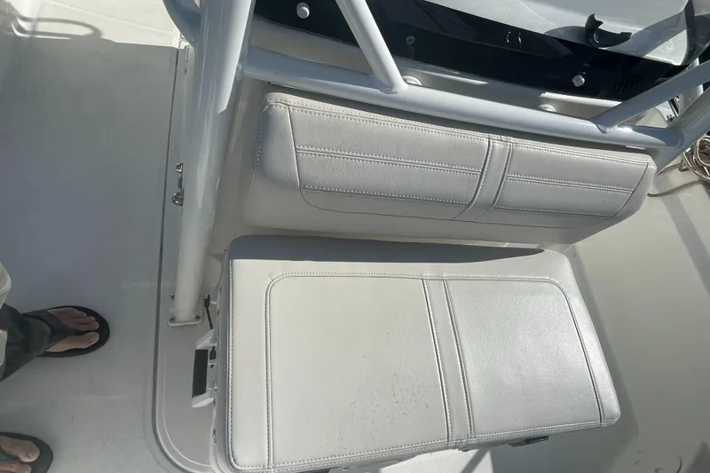 Slide: The Image of 2021 Boston Whaler 210 Montauk boat interior with cushioned seating and deck view. - 4