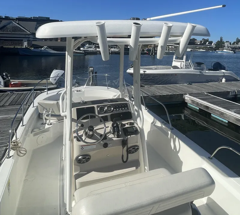 Slide: The Image of 2021 Boston Whaler 210 Montauk boat docked at marina, featuring center console and T-top. - 8