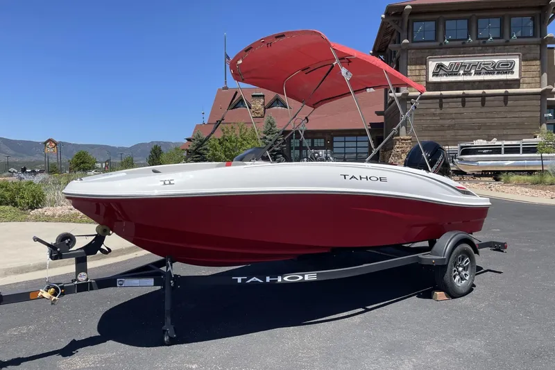 Slide: The Image of 2025 Tahoe T16 boat with red hull and canopy on trailer, parked outdoors. - 3