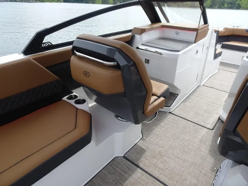 Slide: The Image of 2025 Cobalt R31 boat interior with brown seating and modern design on a lake. - 14