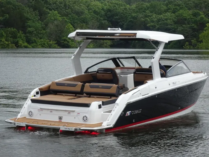 Slide: The Image of 2025 Cobalt R31 boat on a serene lake with lush green background. - 2