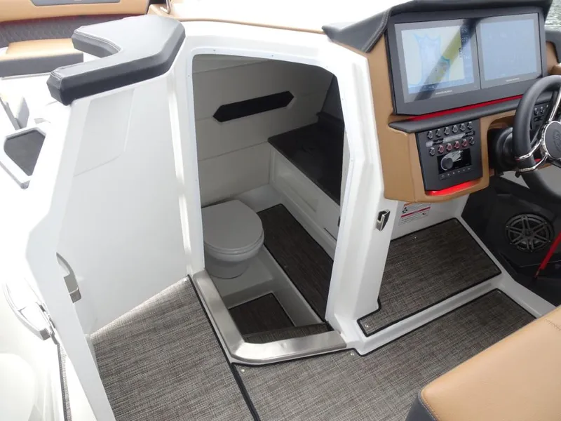 Slide: The Image of 2025 Cobalt R31 boat interior with helm, navigation screens, and compact cabin space. - 20