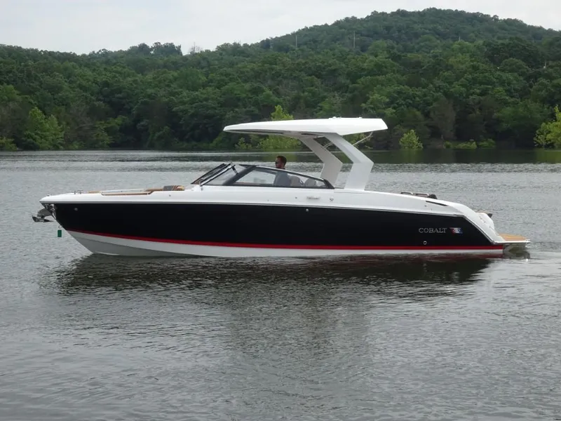 Slide: The Image of 2025 Cobalt R31 boat on a serene lake with lush green forest background. - 4