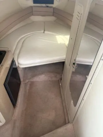 Slide: The Image of 1999 Rinker Fiesta Vee cabin interior with beige upholstery and compact layout. - 10