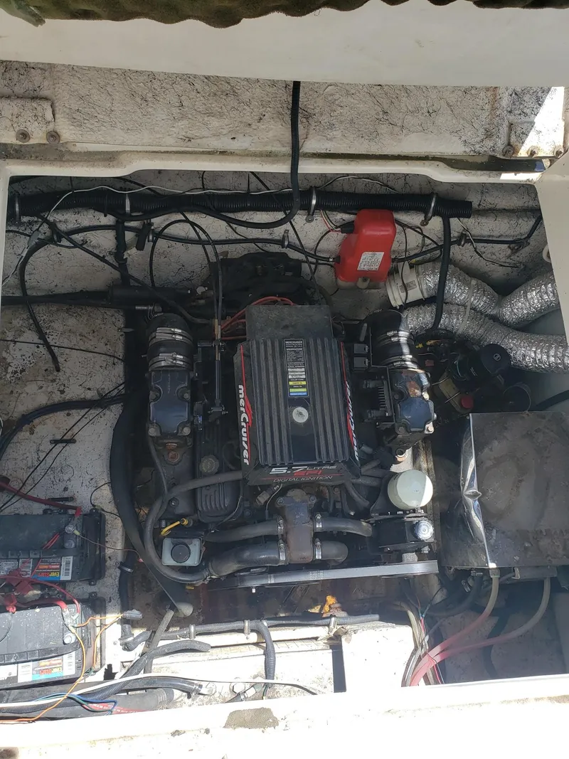 Slide: The Image of Engine compartment of a 1999 Rinker Fiesta Vee boat, featuring a MerCruiser engine. - 12