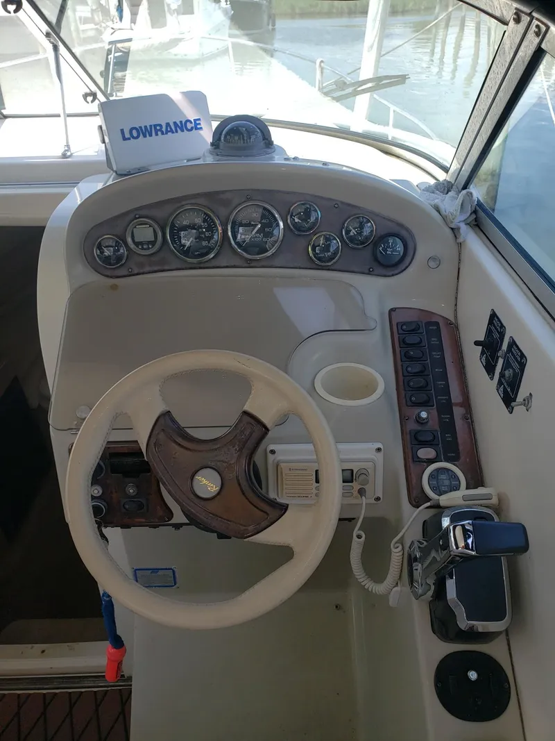 Slide: The Image of 1999 Rinker Fiesta Vee boat dashboard with steering wheel and control panel. - 4