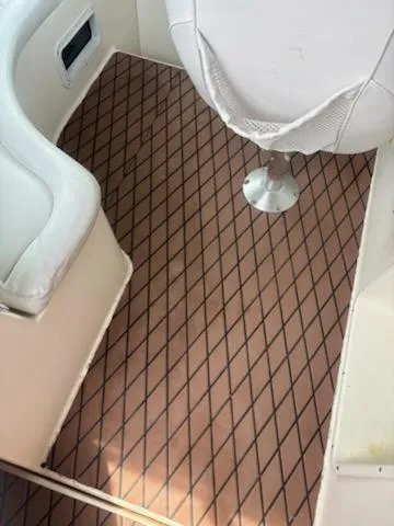 Slide: The Image of 1999 Rinker Fiesta Vee boat interior with diamond-patterned flooring and white seating. - 5