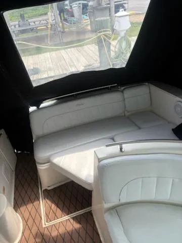 Slide: The Image of 1999 Rinker Fiesta Vee boat interior with white seating and wood-patterned flooring. - 7