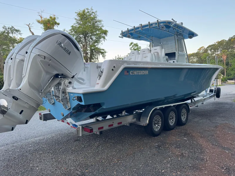 Slide: The Image of 2025 Contender 39ST boat on trailer with Yamaha engines, parked outdoors. - 11